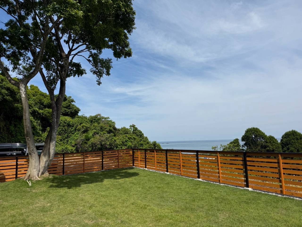 大きな木と海を望むMARISOLの天然芝ドッグラン
